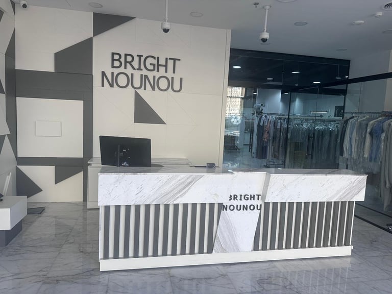 Modern clothing boutique storefront with Bright Nounou branding, marble counter, and geometric wall design