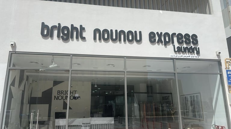 Storefront with Bright Nounou Express laundry sign above glass entrance doors
